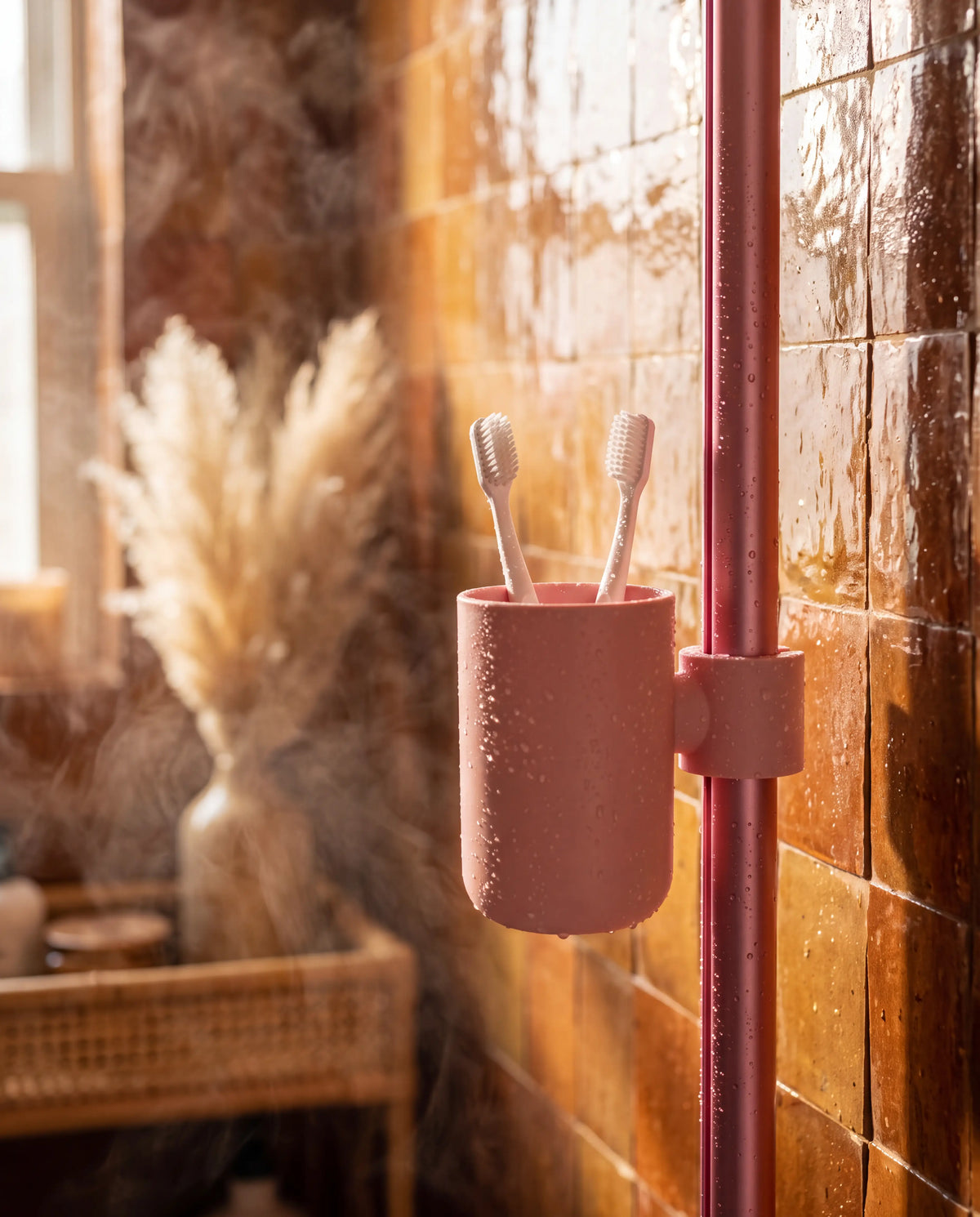 Gobelet Showrz rose clipsé sur la barre de douche